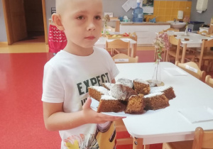 Piotrek trzyma talerz z ciastem